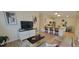 Spacious living room with modern decor, a large television, and a view into the kitchen at 3621 Amelia Ave, The Villages, FL 32162