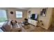 Comfortable living room featuring a sofa, television, and view of the rear yard at 3621 Amelia Ave, The Villages, FL 32162