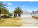 Single-story house with a white garage door and palm trees in the front yard at 3962 Neighborly Way, The Villages, FL 32163