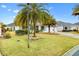 Landscaped yard with palm trees and a single-story house at 3962 Neighborly Way, The Villages, FL 32163