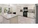 L-shaped kitchen island with granite countertops and white cabinets at 3962 Neighborly Way, The Villages, FL 32163