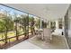 Screened porch with table and chairs, overlooking yard at 3962 Neighborly Way, The Villages, FL 32163