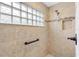 Walk-in shower with glass block window and neutral tile at 3962 Neighborly Way, The Villages, FL 32163