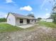 Home's backyard with patio, shed, and large grassy area at 39727 Redbud Rd, Lady Lake, FL 32159