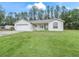 Single-story house with a white exterior, two-car garage, and a covered porch at 39727 Redbud Rd, Lady Lake, FL 32159