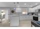 Modern white kitchen with stainless steel appliances and breakfast bar at 419 Cambio Ct, The Villages, FL 32159