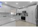 Modern white kitchen with stainless steel appliances and L-shaped counters at 419 Cambio Ct, The Villages, FL 32159