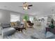 Bright living room with grey sectional sofa, coffee table, and view into dining area at 419 Cambio Ct, The Villages, FL 32159