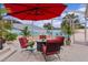 Covered patio with red seating, fire pit, and beach mural at 419 Cambio Ct, The Villages, FL 32159