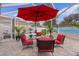 Spacious covered patio with comfortable seating and red umbrella at 419 Cambio Ct, The Villages, FL 32159