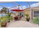 Relaxing patio with covered seating area, hot tub, and lush tropical plants at 419 Cambio Ct, The Villages, FL 32159