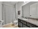 Clean bathroom with granite countertop and striped shower curtain at 4637 Cragmere Loop, Clermont, FL 34711