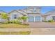 Two-story house with gray siding, blue doors, and a brick driveway at 4637 Cragmere Loop, Clermont, FL 34711