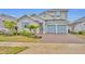 Two-story house with gray siding, blue doors, and a brick driveway at 4637 Cragmere Loop, Clermont, FL 34711