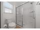 Clean bathroom with a toilet next to a large glass enclosed shower and window at 4654 Ramsell Rd, The Villages, FL 32163