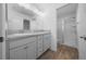 Bathroom with double sink vanity, wood-look floors, and glass shower doors at 4654 Ramsell Rd, The Villages, FL 32163