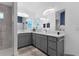 Bright bathroom boasts dual sinks, gray vanities, and modern fixtures at 4923 Lawler Loop, The Villages, FL 32163