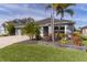 Gray three-car garage home with palm trees and landscaped yard at 4923 Lawler Loop, The Villages, FL 32163