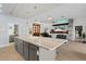 Modern kitchen island with granite countertop and gray cabinets at 4923 Lawler Loop, The Villages, FL 32163