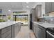 Bright kitchen featuring gray cabinets, stainless steel appliances, and a view to the outdoor pool at 4923 Lawler Loop, The Villages, FL 32163