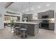 Modern kitchen with gray cabinetry, quartz countertops, large island, and stainless steel appliances at 4923 Lawler Loop, The Villages, FL 32163