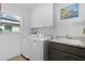 Functional laundry room with modern appliances, ample storage, and natural light from a nearby window at 4923 Lawler Loop, The Villages, FL 32163