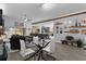 Open-concept living room with a glass dining table and an adjacent kitchen with modern appliances at 4923 Lawler Loop, The Villages, FL 32163