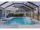 Enclosed pool with patio and lake view at 4923 Lawler Loop, The Villages, FL 32163