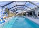 Inviting screened pool with lounge chairs, basketball hoop, and patio furniture at 4923 Lawler Loop, The Villages, FL 32163