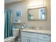 Cozy bathroom featuring bright white cabinets, granite countertop, and a decorative mirror at 502 San Marino Dr, Lady Lake, FL 32159