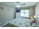 Well-lit bedroom featuring floral bedding, window with blinds, dresser and chair at 502 San Marino Dr, Lady Lake, FL 32159