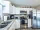 Bright kitchen with stainless steel appliances, granite countertops, and white cabinetry at 502 San Marino Dr, Lady Lake, FL 32159