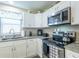 Well-lit kitchen with granite countertops, stainless steel appliances, and white cabinets at 502 San Marino Dr, Lady Lake, FL 32159