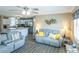 Open-concept living room with gray furniture and a view of the modern kitchen at 502 San Marino Dr, Lady Lake, FL 32159