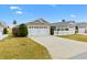 Two-car garage with white doors and landscaping at 5415 Kate Ct, The Villages, FL 32163