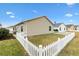 Side view of beige house with white picket fence at 5415 Kate Ct, The Villages, FL 32163