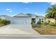 Two-story house with a three-car garage and landscaped front yard at 5676 Patterson Loop, The Villages, FL 32163