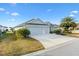 House exterior showcasing a three-car garage and lush landscaping at 5676 Patterson Loop, The Villages, FL 32163