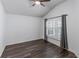 Neutral bedroom features dark wood floors and natural light from the shuttered window at 583 Arruda Ter, The Villages, FL 32162