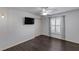 Neutral bedroom features dark wood floors and a sunny window with shuttered blinds at 583 Arruda Ter, The Villages, FL 32162