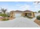 Single-story home featuring an attached garage, driveway, and manicured landscaping with gravel beds at 583 Arruda Ter, The Villages, FL 32162