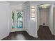 View of foyer showing decorative front door and sidelights, archway and dark wood-style flooring at 583 Arruda Ter, The Villages, FL 32162