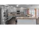Spacious kitchen features stainless steel appliances, granite countertops, and gray cabinets at 583 Arruda Ter, The Villages, FL 32162