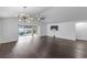 Open-concept living room with modern lighting, hardwood floors, and sliding doors to the patio at 583 Arruda Ter, The Villages, FL 32162