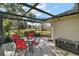 Screened patio with table, chairs, and pond view at 586 Juniper Way, Tavares, FL 32778