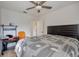 Functional bedroom featuring a ceiling fan, workspace, and light gray bedspread at 604 Palmetto Dr, Mascotte, FL 34753