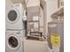 A compact laundry area features a stacked washer and dryer, alongside the home's water heater and HVAC system at 604 Palmetto Dr, Mascotte, FL 34753