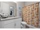 Clean bathroom with granite countertop, white cabinets, and a patterned shower curtain at 729 Calabria Way, Howey In The Hills, FL 34737