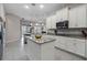 Modern kitchen with island, white cabinets and stainless steel appliances at 729 Calabria Way, Howey In The Hills, FL 34737