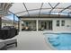 Covered patio with pool, grill, and seating area at 729 Calabria Way, Howey In The Hills, FL 34737